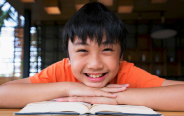 Student looking at book smiling
